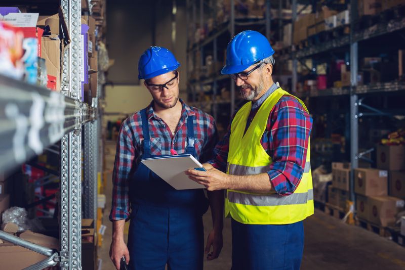Two warehouse workers talking at work